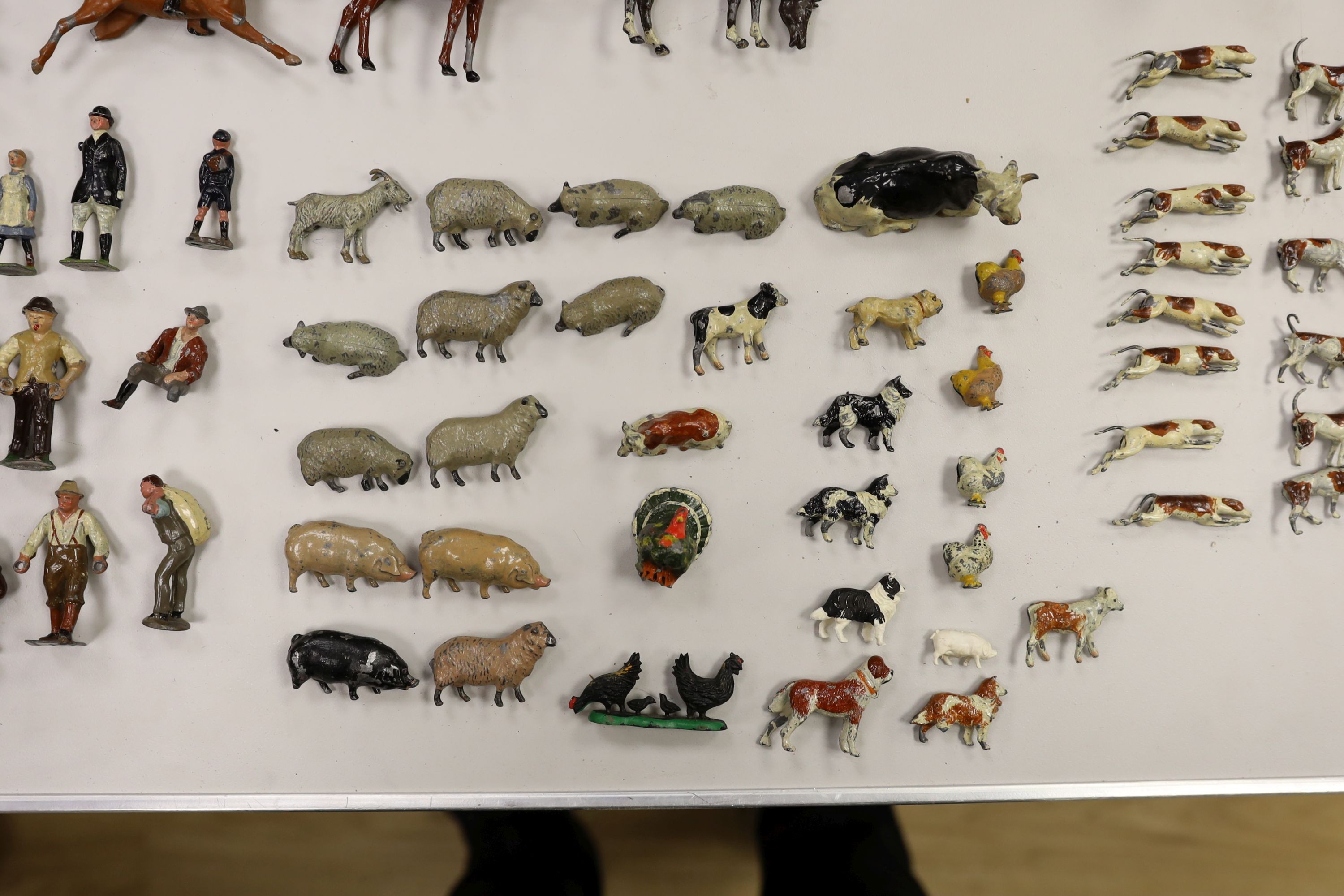A collection of mainly Britains painted lead figures and animals, including huntsmen and hounds, farm workers, animals and wooden buildings